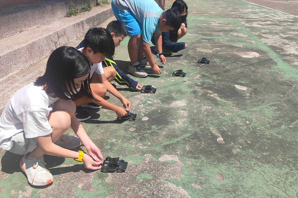 維新國小學童於戶外測試親手組裝的太陽能小車，觀察太陽光能轉換為電能的過程。