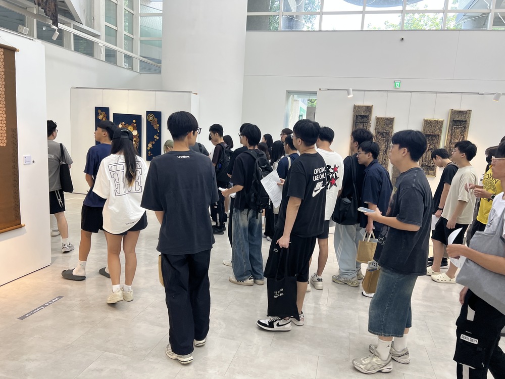 高科大師生近距離欣賞天然染織作品，從植物留下的色彩與紋理，看見每一次染製所形成、難以複製的自然痕跡。