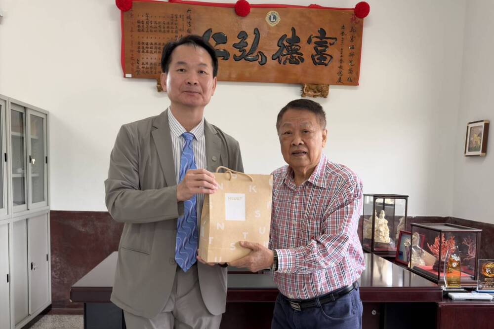 高科大吳忠信校長（左）致贈伴手禮予財團法人富仁教育永續基金會鄭富仁董事長（右）。