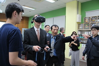 德國福茲堡科技大學校長羅伯特·格雷伯納校長戴上VR顯示器，體驗由資管系師生研發的購物及娛樂平台