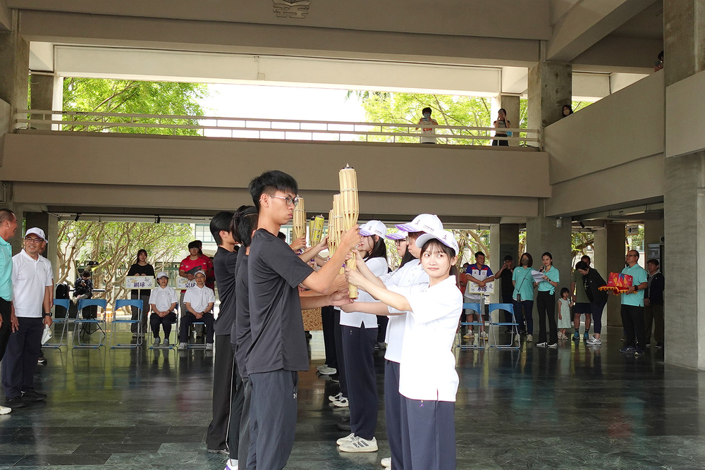 中央大學聖火隊與高科大代表於行政大樓進行聖火交接儀式，象徵全大運精神延續與傳承。