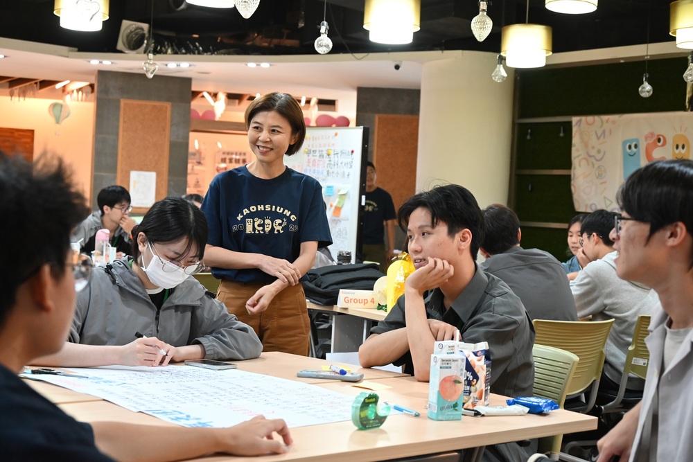 ICDC行前培育課程設計思考工作坊由龔蒂菀老師(圖中立者)及張鐵懷老師共授與學生小組進行討論。